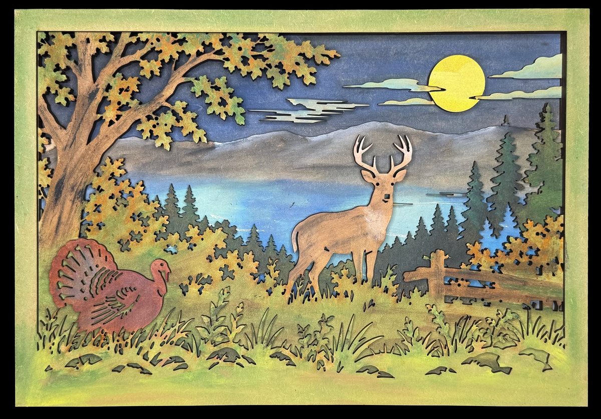 A layered woodland scene in a black frame: a buck standing in a clearing with a turkey in the long grass, a bare tree overhead and a full moon over the hills behind.